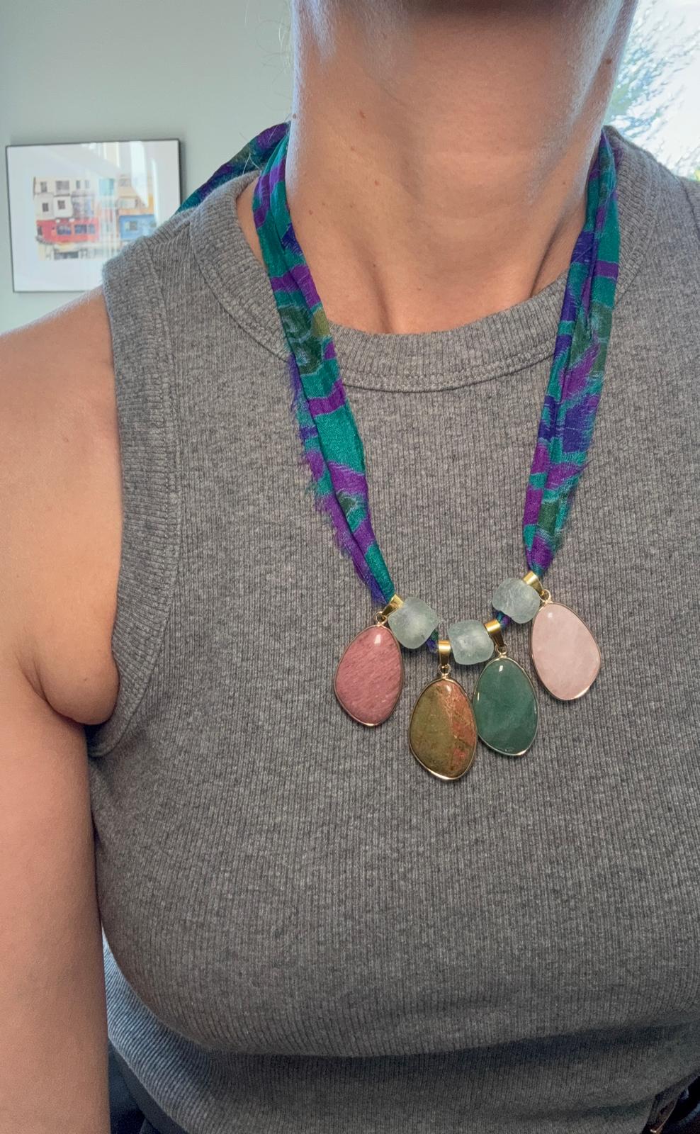 The necklace worn with a white top, the gold-plated bezels and coloured stones in daylight