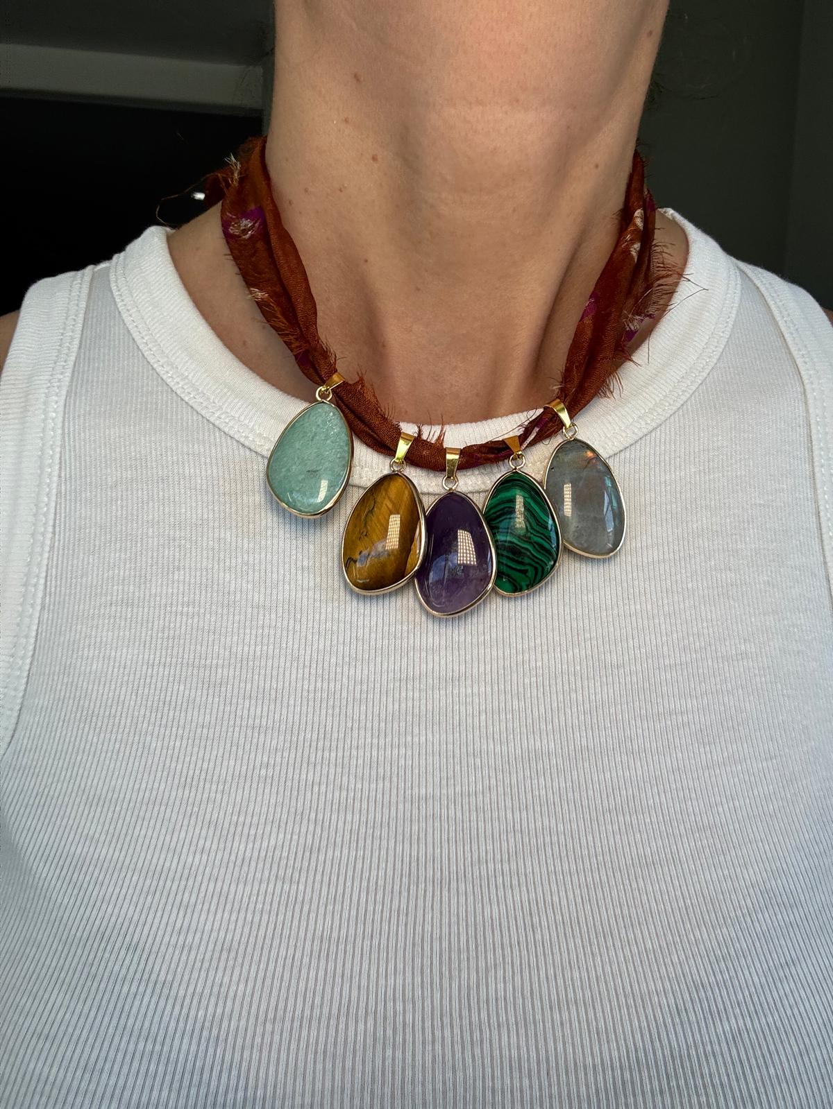 The necklace worn doubled short at the collarbone over a white top