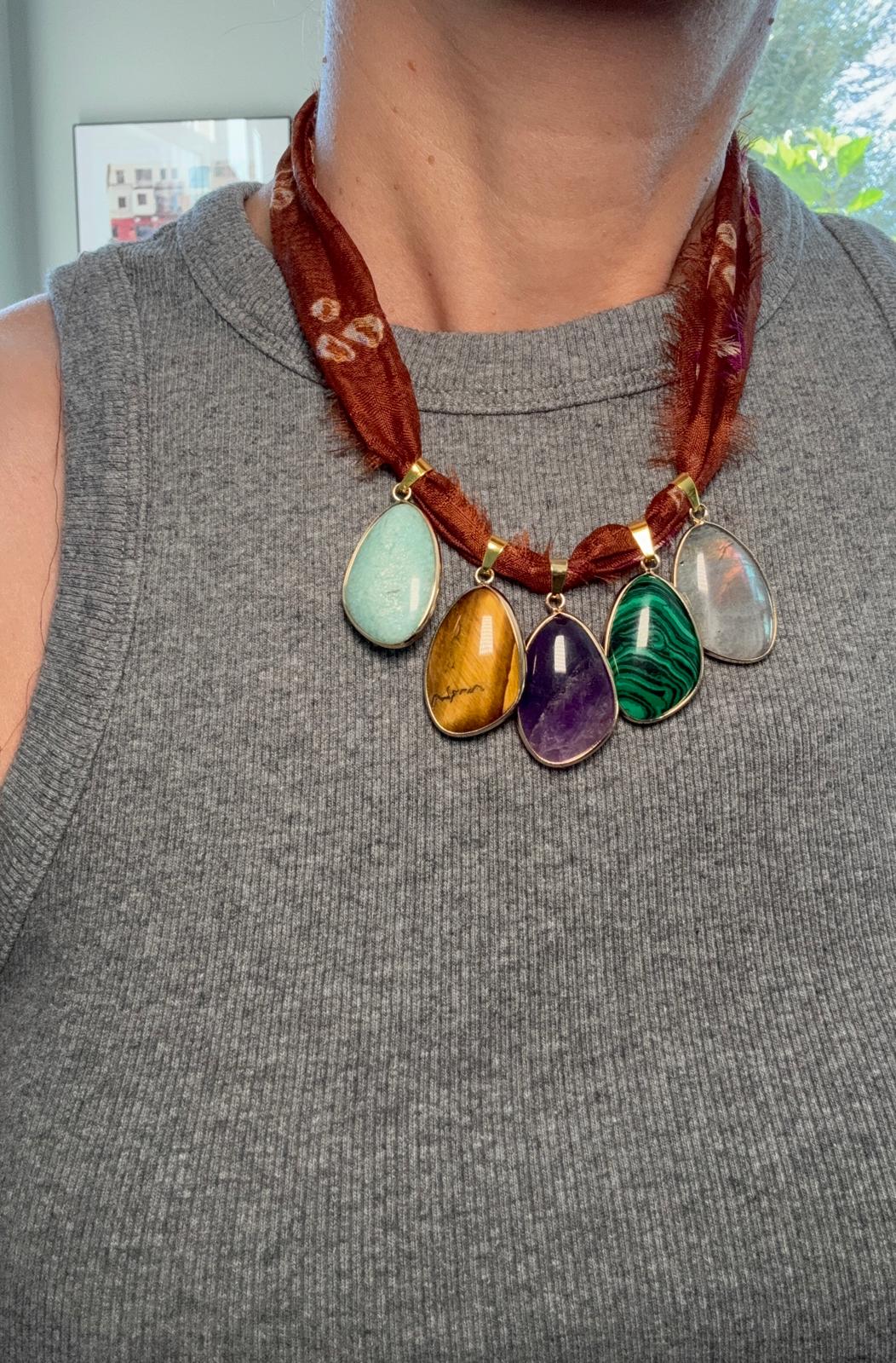The necklace worn, showing the rust silk against the coloured stones