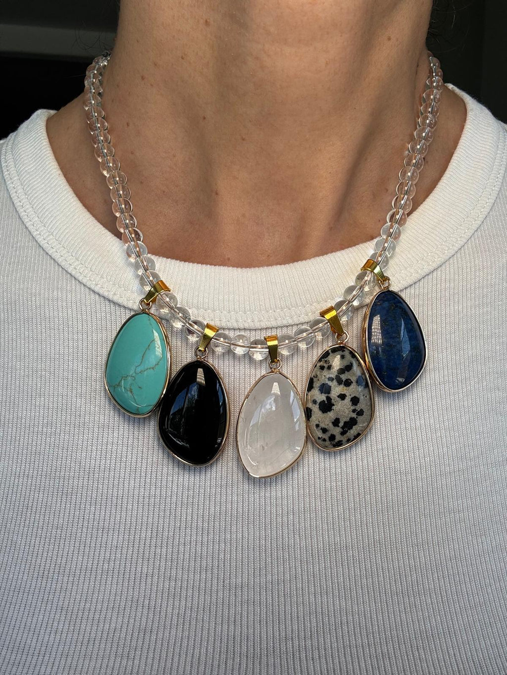 Detail of the worn necklace, the spotted dalmatian jasper and deep blue lapis lazuli in daylight