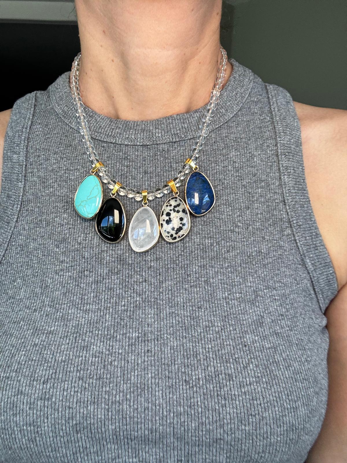 The necklace worn, showing how the clear quartz strand nearly disappears against the skin