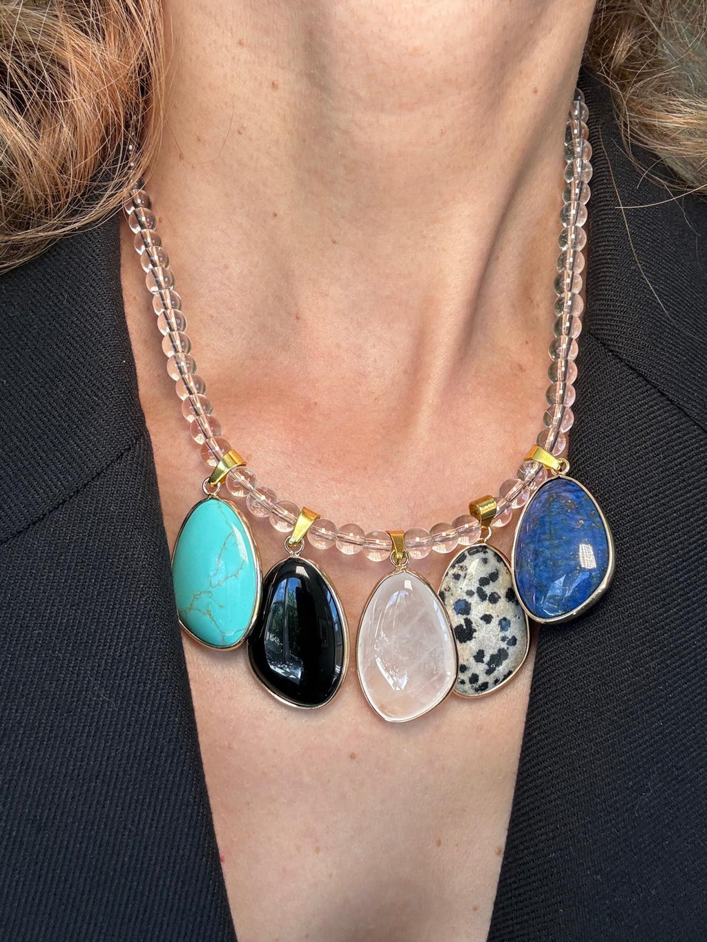 Close view of the clear quartz bead strand and the gold bails joining the stones