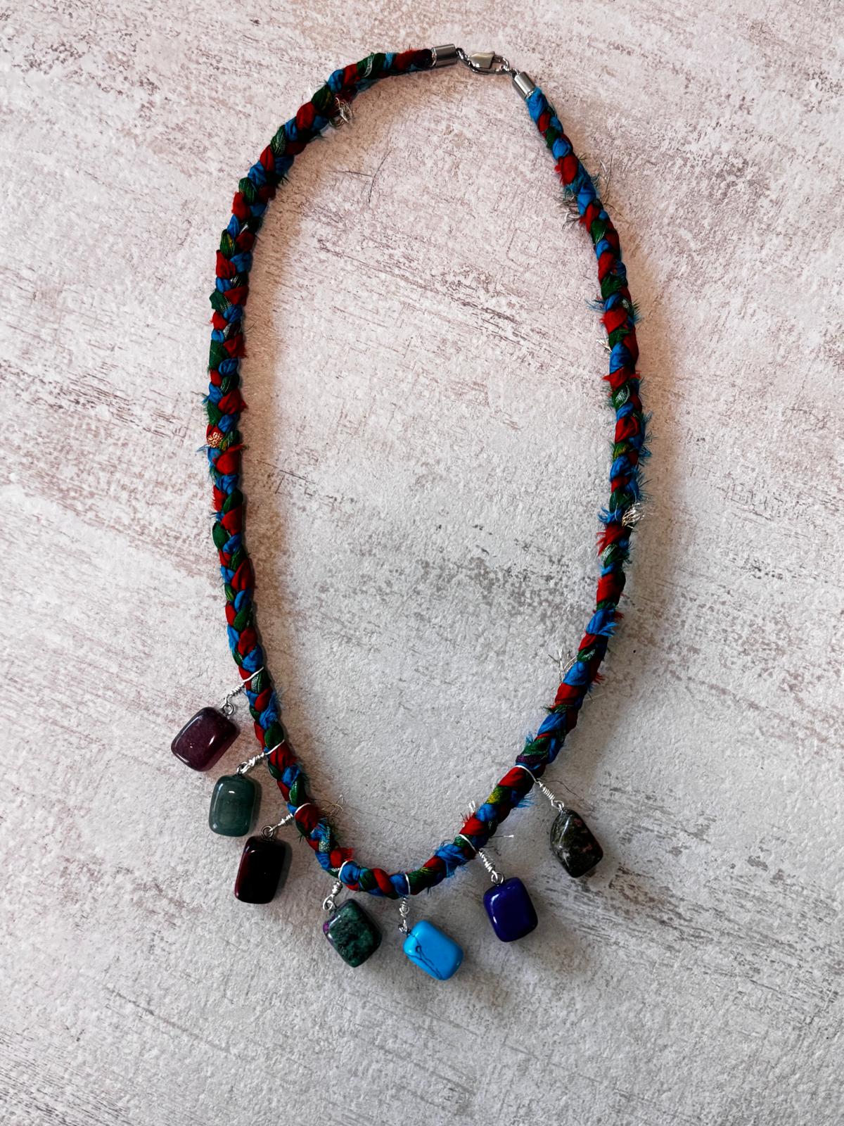 The full necklace laid flat, showing the braided silk cord and the clasp