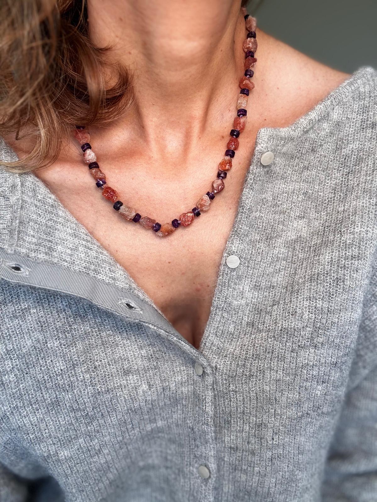 The necklace worn, sitting just below the collarbone
