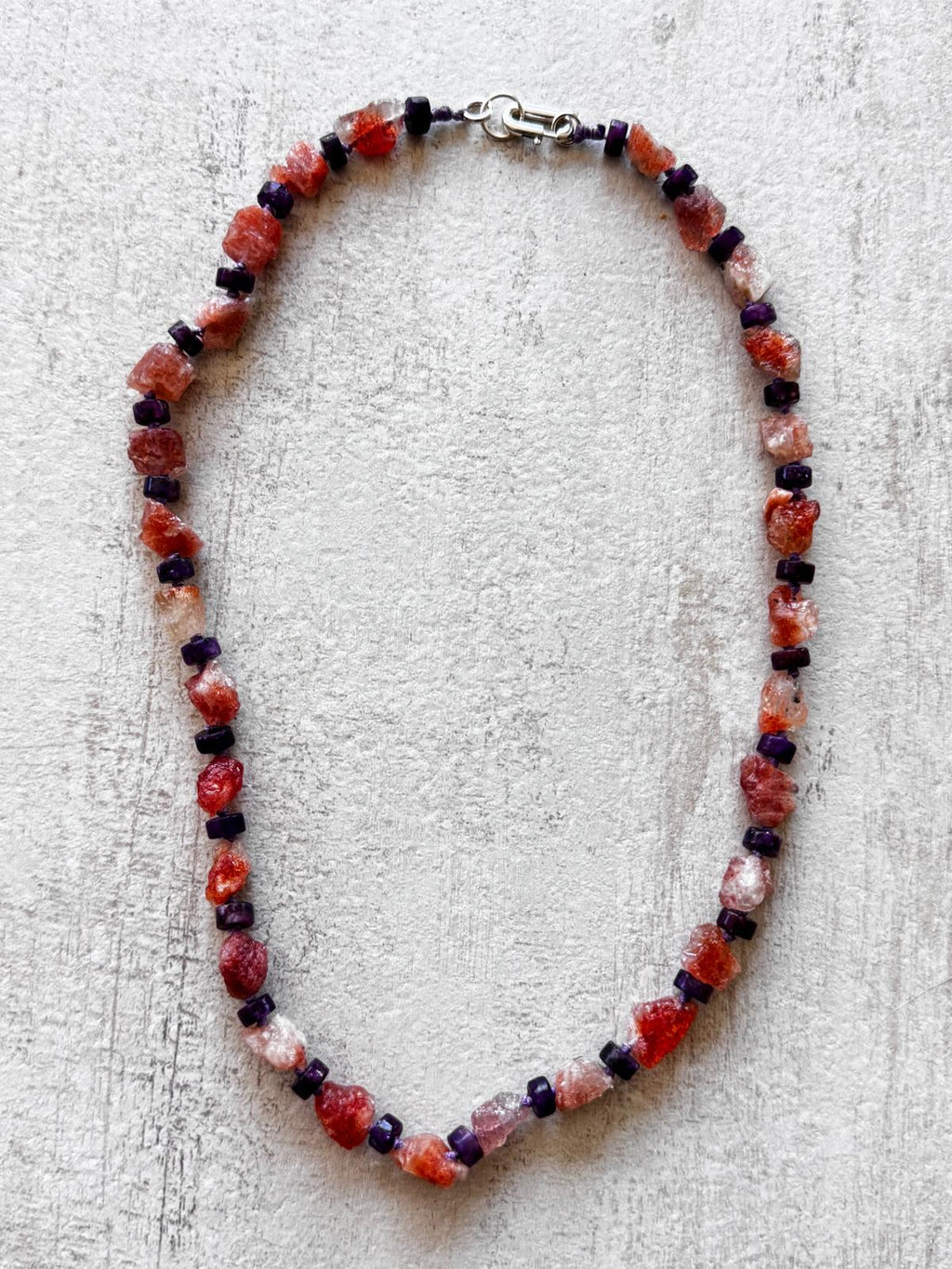 The full necklace laid flat, every sunstone nugget a different rough shape