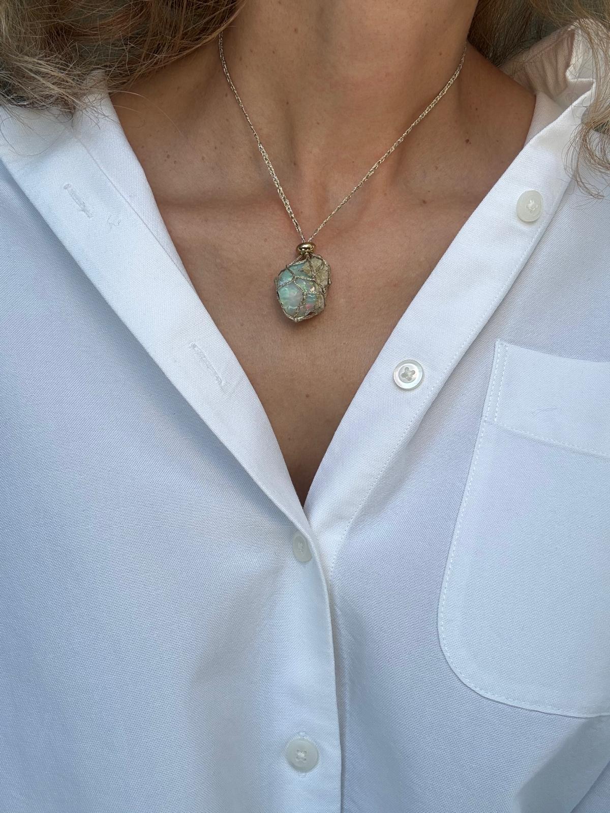 Raw opal pendant on a hand-braided cord, worn close up