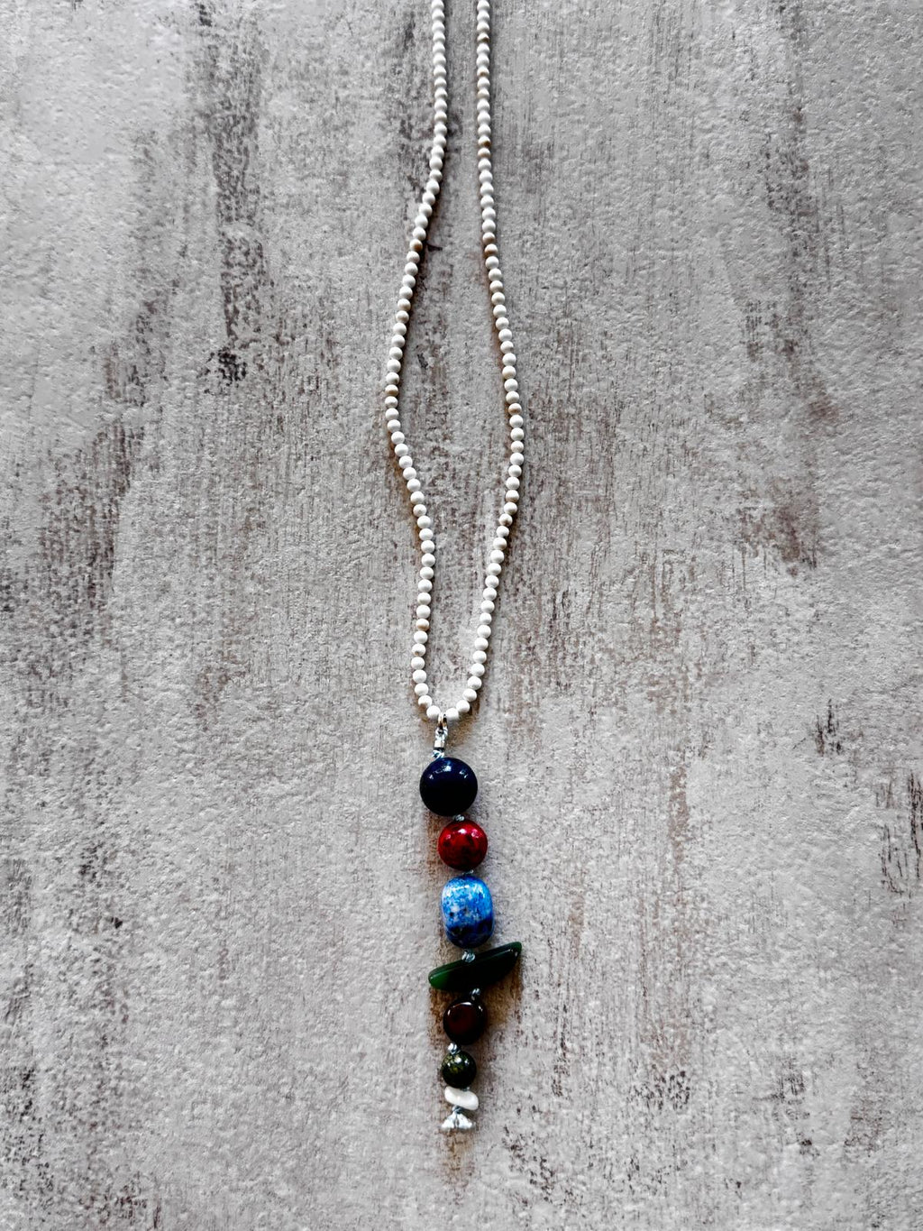 Close view of the drop — lapis lazuli, coral, kyanite, green jasper, tiger's eye, chrysoprase and mother of pearl stacked in a column