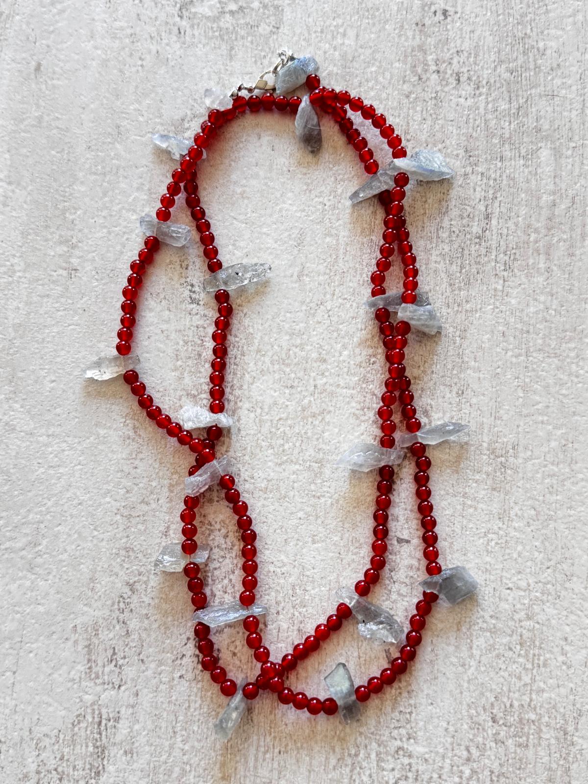The necklace laid flat and doubled, showing the deep red carnelian rounds and the sterling silver lobster clasp