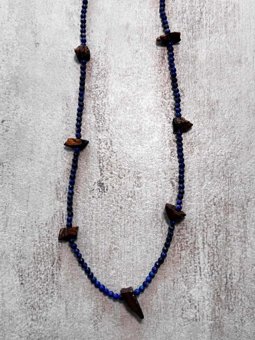 Detail of the lapis strand showing the raw faces of the tiger's eye nuggets