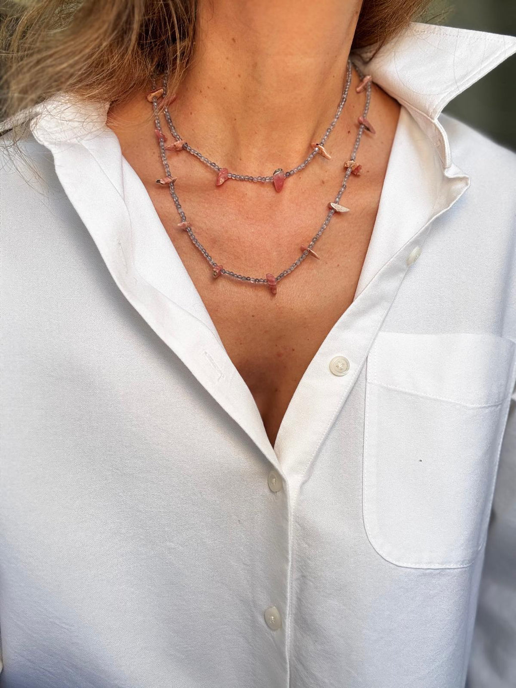 The rhodochrosite and labradorite necklace worn doubled at the throat, pink stone points spaced along two grey strands