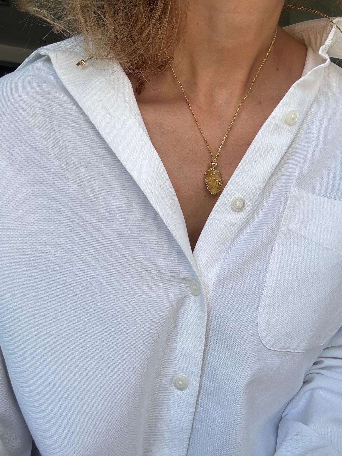 The pendant worn at a shorter setting on the sliding cord, sitting at the collarbone