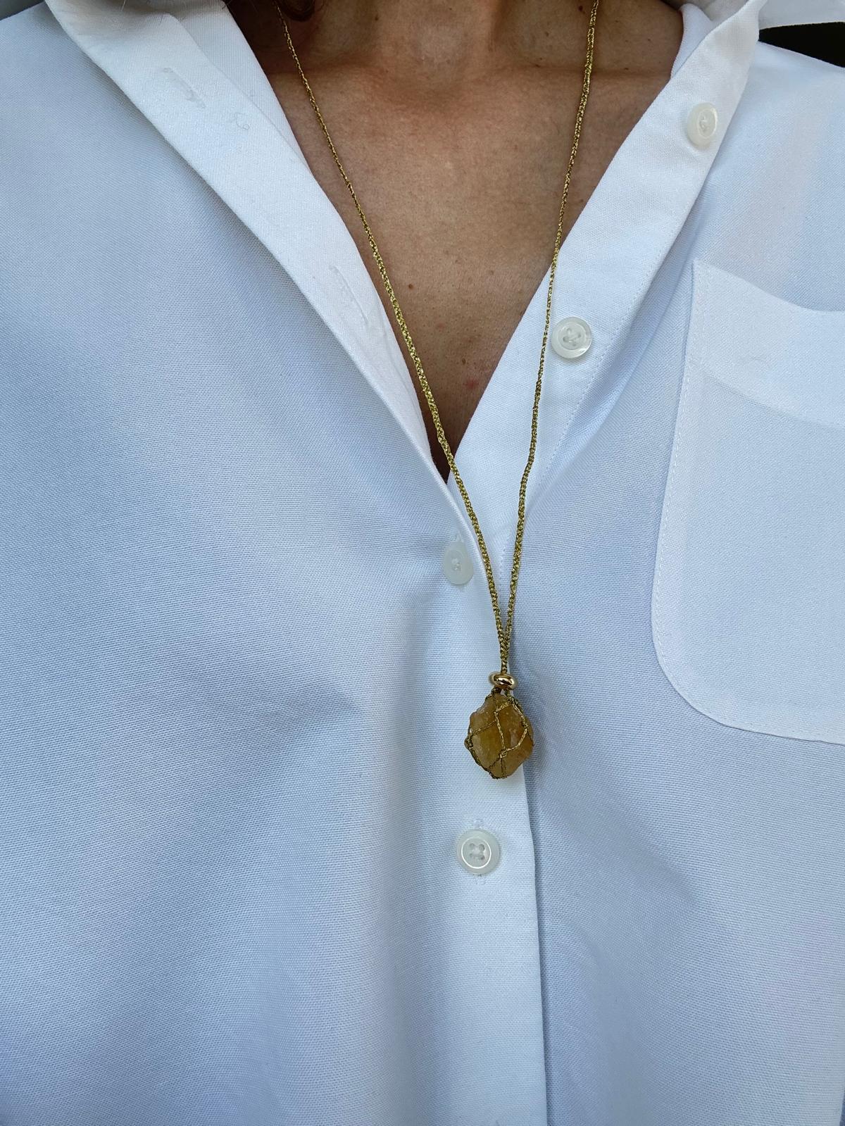 The pendant worn long, hanging well below the collar