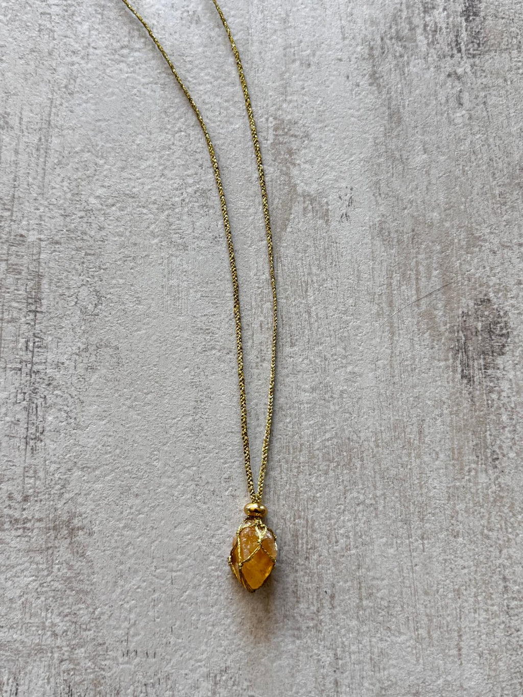 Close view of the raw citrine caught in the golden braid