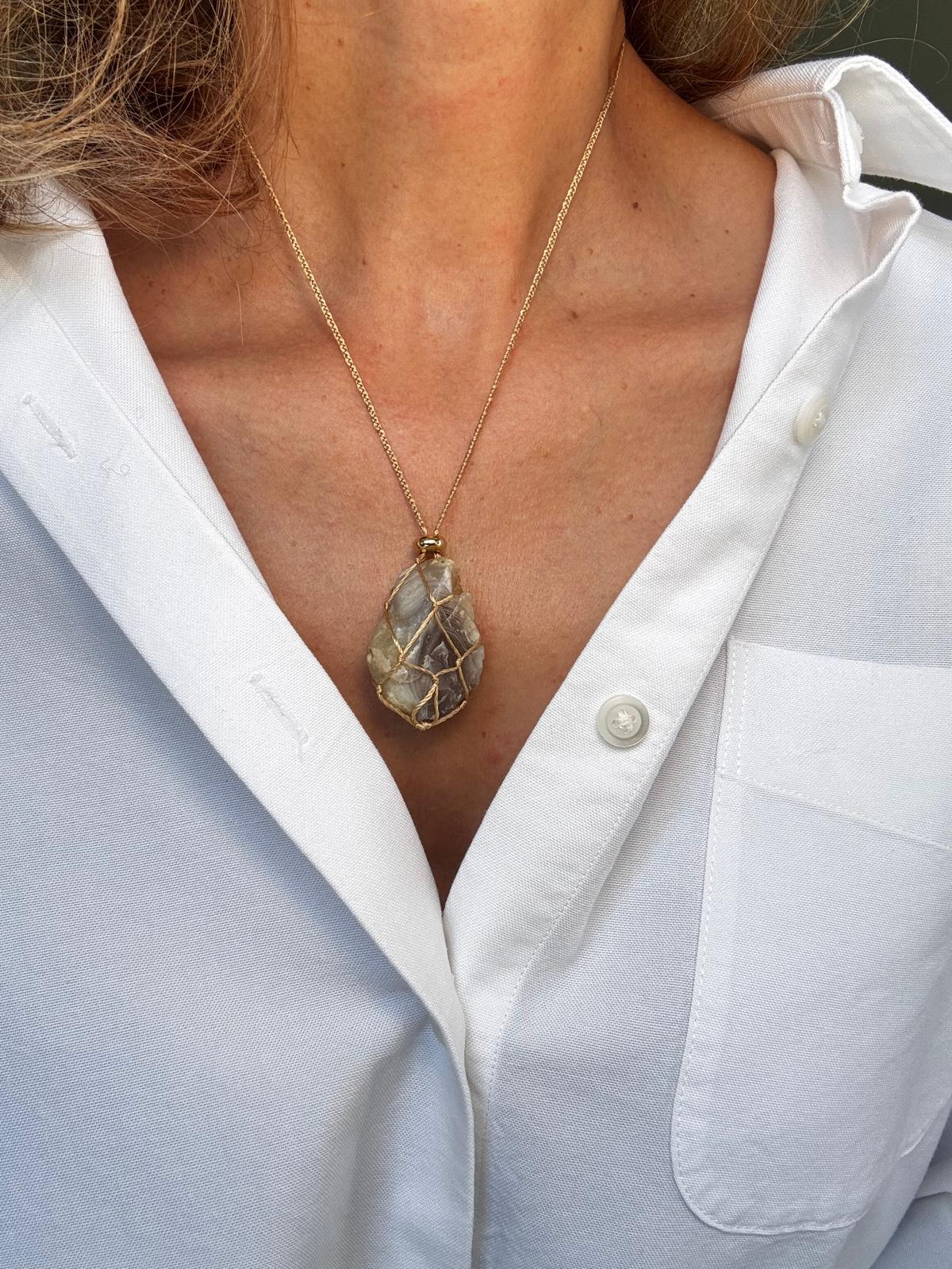 Close view of the banded grey agate inside the silk braid, with the gold-plated spacer above