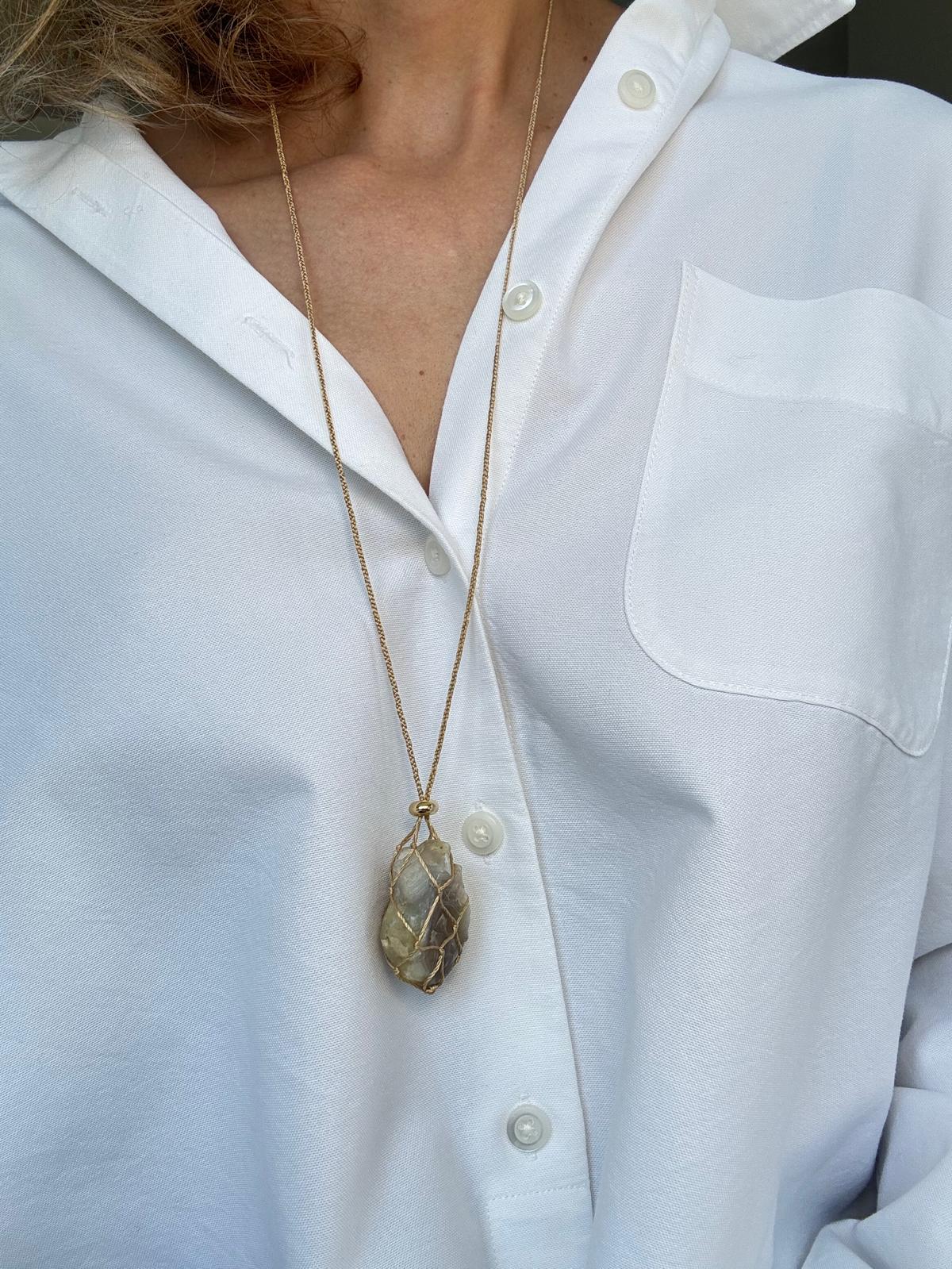 The pendant worn long on the sliding silk cord, hanging at mid-chest