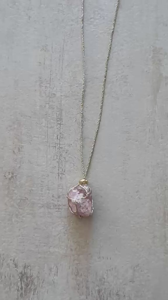 Video of the raw strawberry quartz pendant turning on its braided gold cord