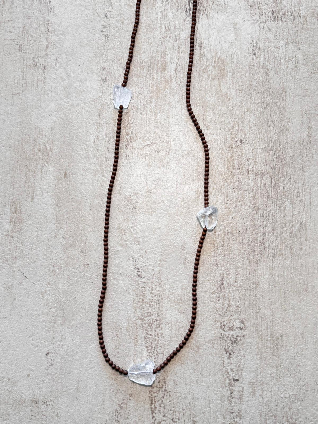 Close view of the matte copper hematite beads and an unpolished clear quartz nugget