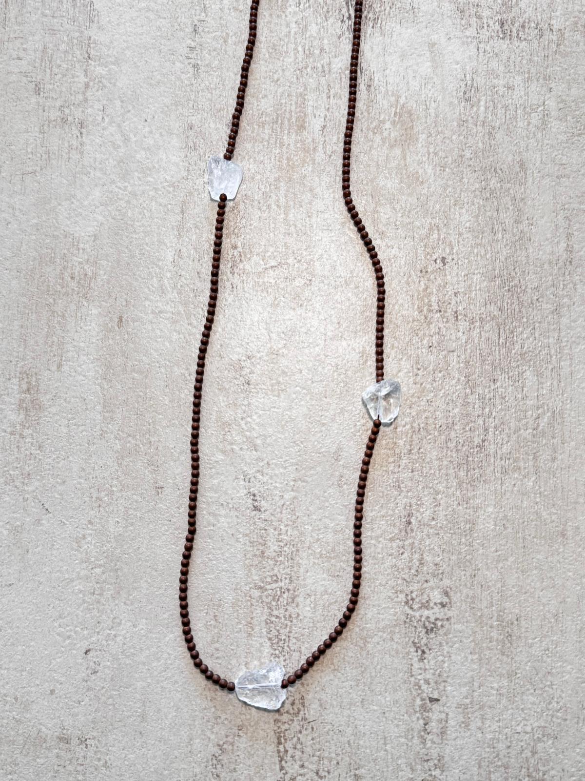 Close view of the matte copper hematite beads and an unpolished clear quartz nugget