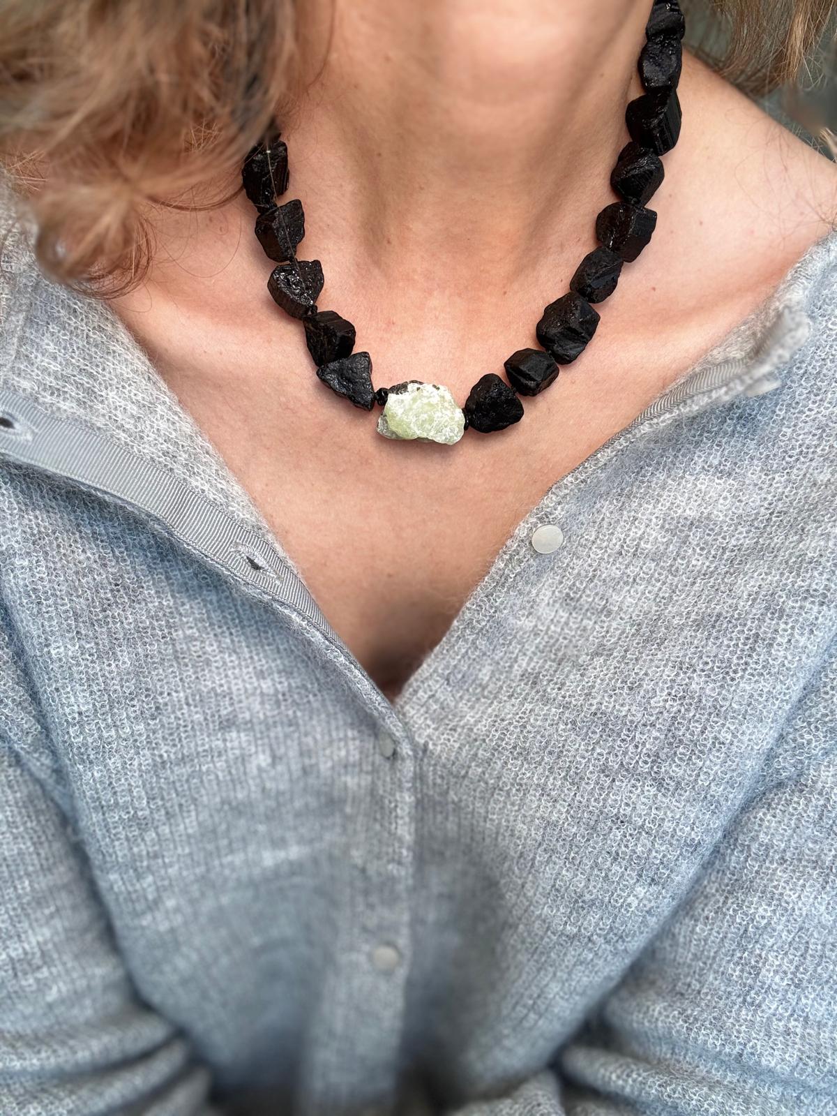 The collar worn at the base of the neck, showing how close and heavy the rough stones sit