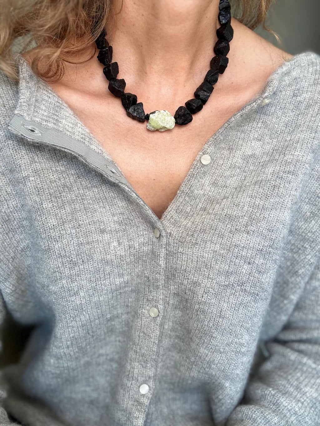Close view of the raw tourmaline faces and the pale prehnite at the front