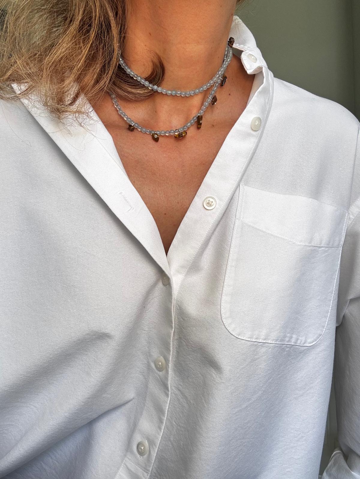 The aquamarine necklace worn doubled as a close two-strand choker, small tiger's eye nuggets hanging along the lower strand