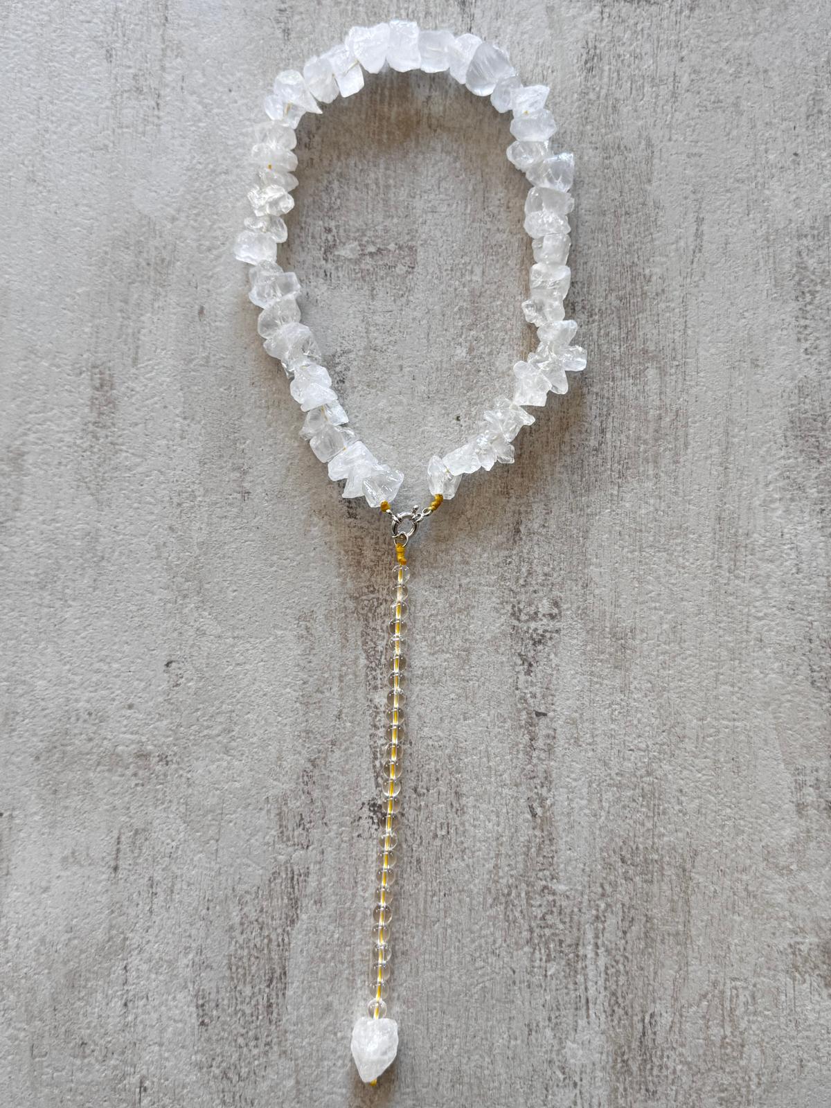 The necklace laid flat with the drop hanging from the sterling silver snap hook, yellow thread visible through the stone