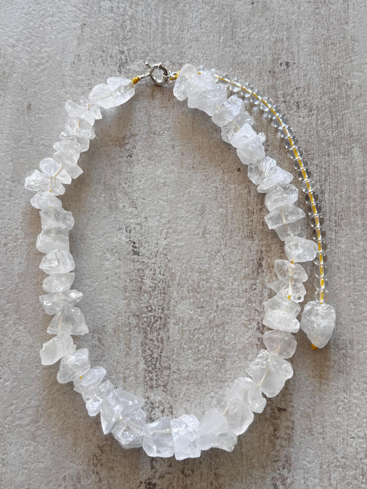 The collar laid flat beside the removable drop of round quartz beads ending in a rough chunk
